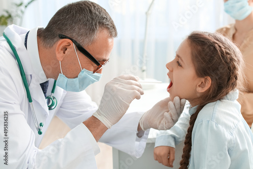 Doctor examining little gir...