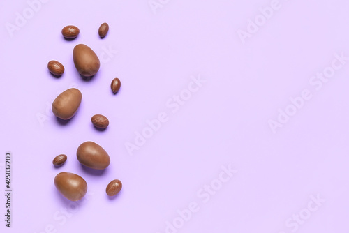 Delicious chocolate eggs on purple background
