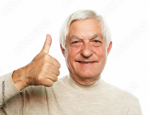 Senior man doing happy thumbs up gesture with hand.