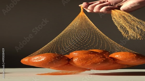 hand holds a net with tangerines