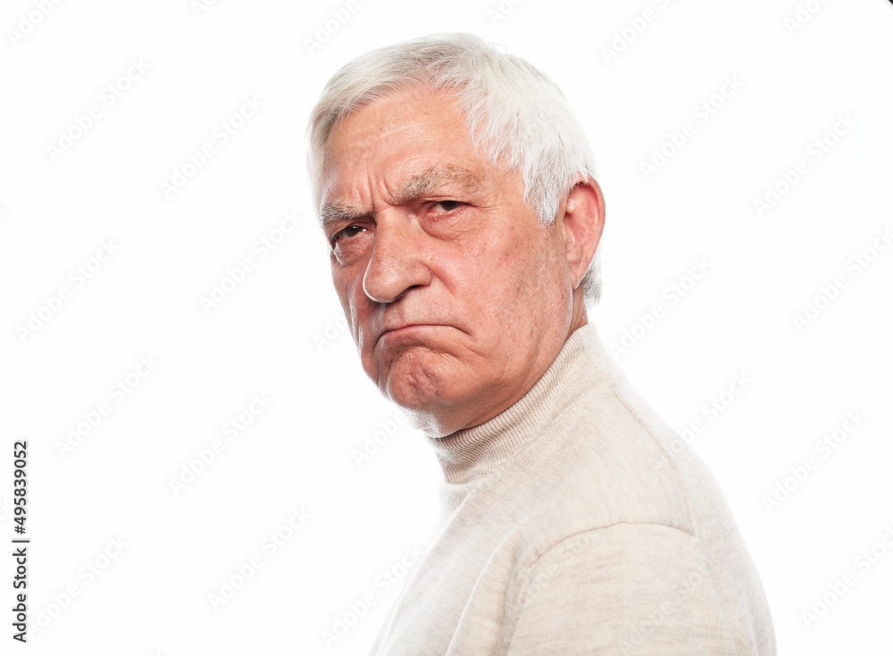 Senior man with gray hair frowns and looks displeased over white background. Senior man with gray hair frowns and looks displeased over white background.