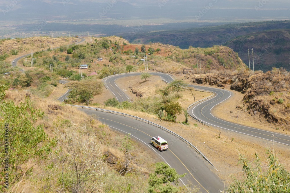 Aerial view of a meandering highway against a mountain background in the Iten- Kabarnet Road, Baringo County, Kenya