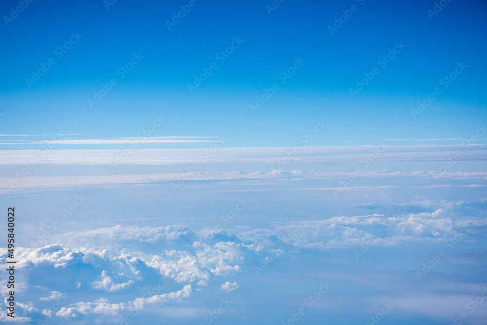 飛行機から見た青く澄んだ空と雲