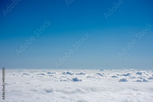 飛行機から見た青く澄んだ空と雲