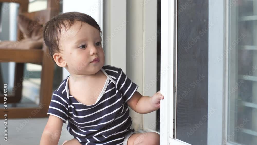 A cute 8-10 month old baby explores the world and learns the work of opening a sliding door by opening and closing it, after which he crawls towards the camera with a smile. A cute 8-10 month old baby explores the world and learns the work of opening a sliding door by opening and closing it, after which he crawls towards the camera with a smile.