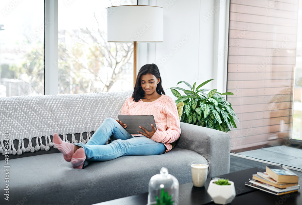 What I prefer to do on the weekend. Cropped shot of a beautiful young woman using a tablet while chilling on the sofa in the living room at home. What I prefer to do on the weekend. Cropped shot of a beautiful young woman using a tablet while chilling on the sofa in the living room at home.