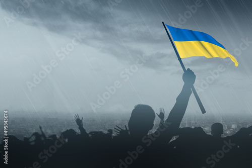Silhouette of crowd people holding Ukraine flag