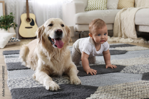 Cute little baby with adorable dog on floor at home © New Africa