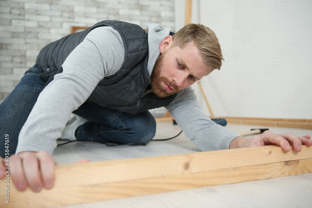 man is engaged in laying laminate wood floor man is engaged in laying laminate wood floor