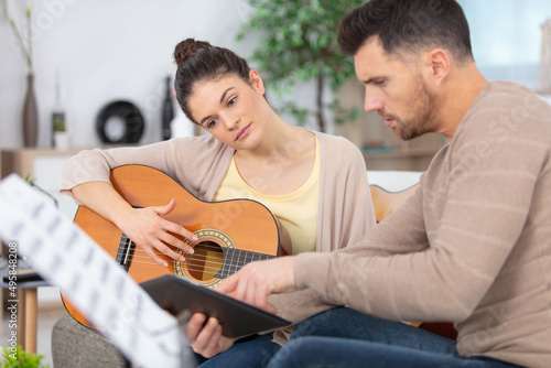 Obraz na plátně male musician teaches female student how to play the guitar