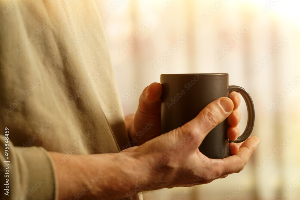 Male hands close-up with a cup of coffee. Black cup in the hands of a man Male hands close-up with a cup of coffee. Black cup in the hands of a man