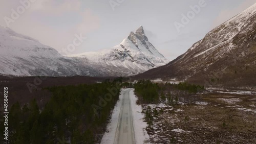 Winter road leading straight to Otertinden mountain in northern Norway. 
4K aerial straight ascent drone shot.. photo