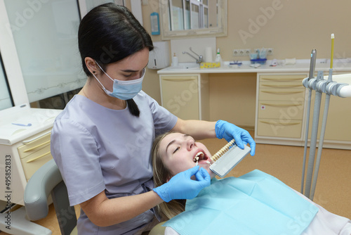 dentist selects the color of the client s tooth