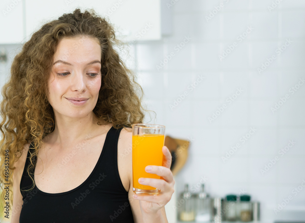 healthy caucasian woman hold orange juice glass, look at orange juice glass in kitchen with copy space. beautiful caucasian woman cooking healthy diet fruit or vegetable in kitchen healthy caucasian woman hold orange juice glass, look at orange juice glass in kitchen with copy space. beautiful caucasian woman cooking healthy diet fruit or vegetable in kitchen