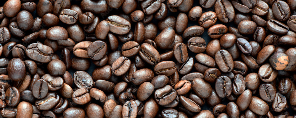 Fresh coffee beans scattered as a background or texture. Fresh coffee beans scattered as a background or texture.