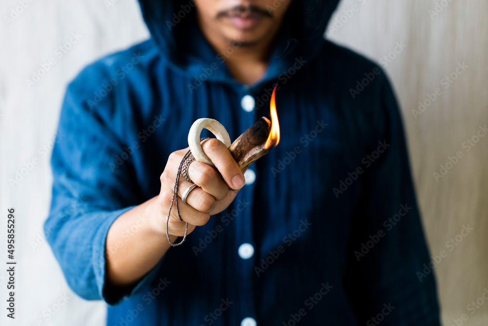 Man person lighting a palo santo and hand holding Himalaya Salt stone. meditation concept Man person lighting a palo santo and hand holding Himalaya Salt stone. meditation concept