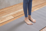female legs on gray yoga mat, workout at home