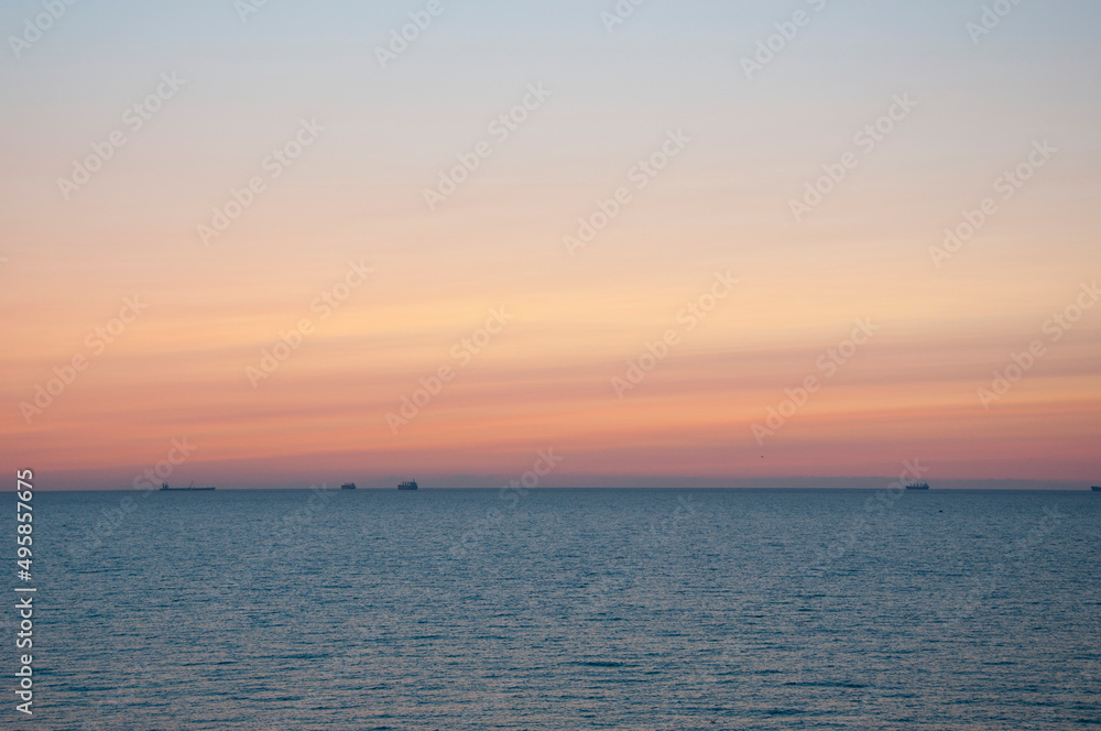 sunrise sky and sea with ship on horizon, summer