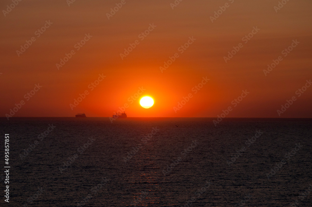 sundown sky and sea with ship on horizon, summer sundown sky and sea with ship on horizon, summer