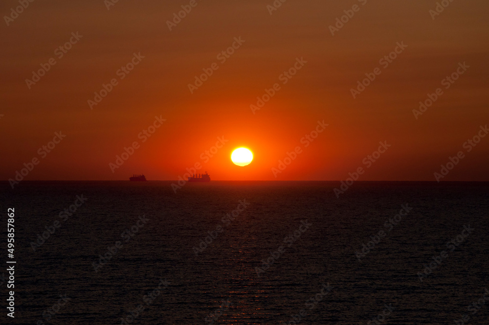 sundown sky and sea with ship on horizon, bali
