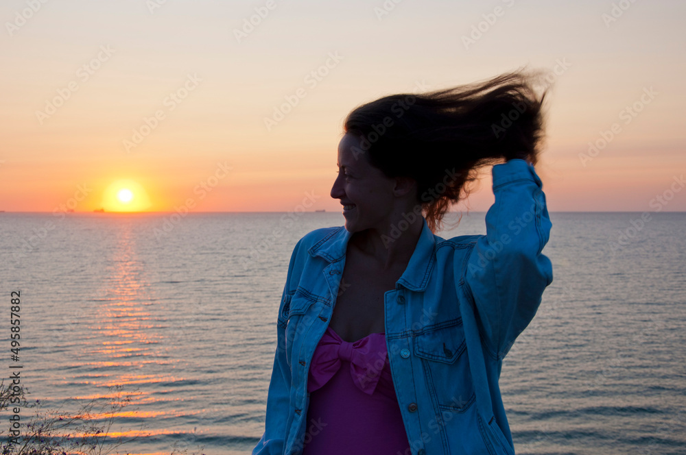 happy young lady look at summer sunset sun and sky with seascape happy young lady look at summer sunset sun and sky with seascape