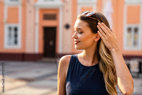 Close-up portrait of beautiful caucasian woman with charming smile walking outdoors © NDABCREATIVITY