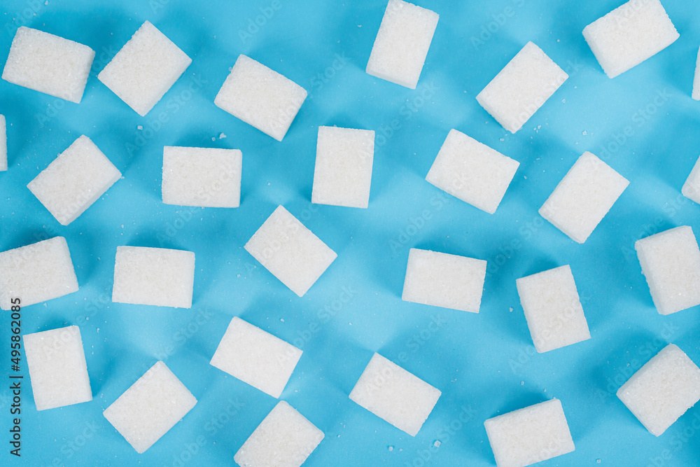 Natural white sugar cubes isolated on blue background Natural white sugar cubes isolated on blue background