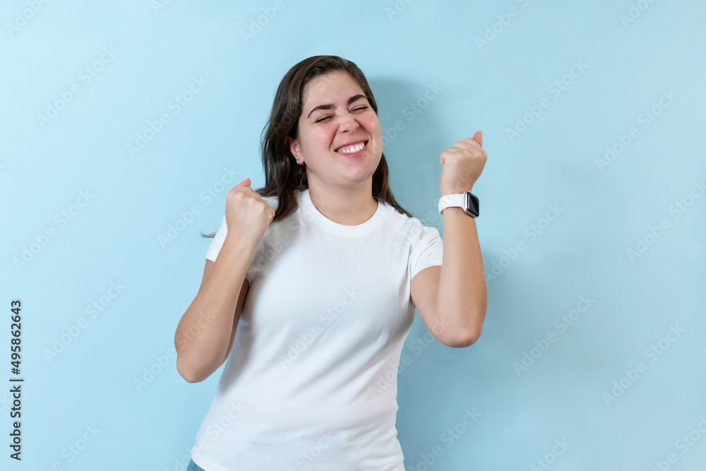 Fototapeta premium Excited girl on light blue background.
