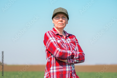 Portrait of female farmer in cultivated wheat seedling field