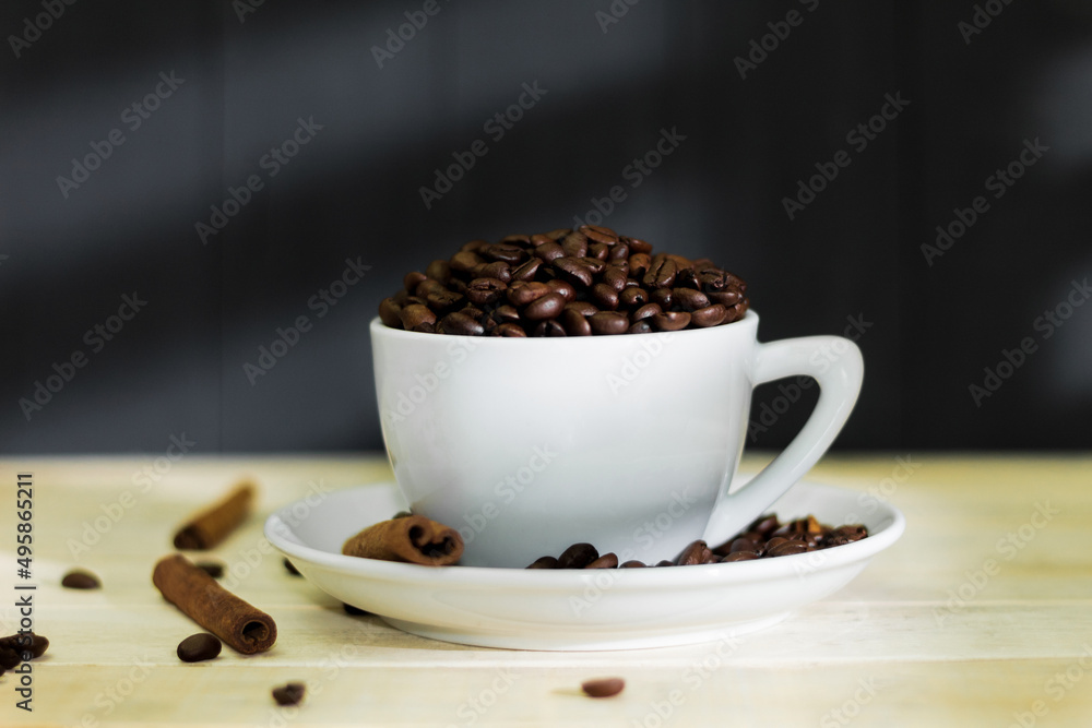 Obraz premium White cup and saucer with fragrant coffee beans