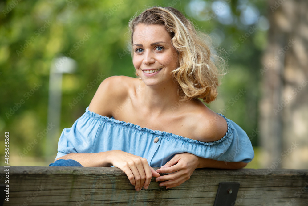 happy woman relaxing on bench in the lawn happy woman relaxing on bench in the lawn
