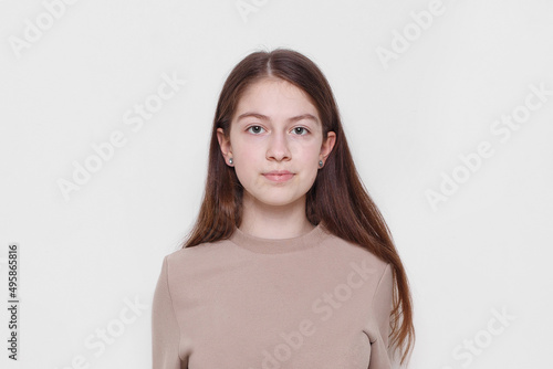 Front portrait of a beautiful teenage girl   looking at camera  isolated on a white background. Copy space.