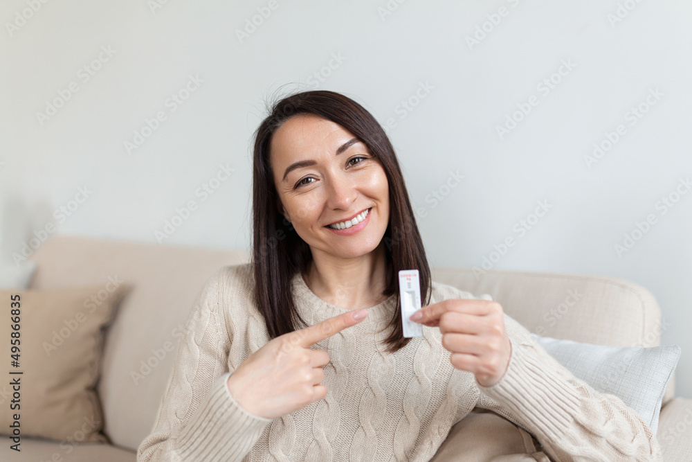 Close-up shot of woman's hand holding a negative test device. Happy Asian woman showing her negative Coronavirus - Covid-19 rapid test. Coronavirus Close-up shot of woman's hand holding a negative test device. Happy Asian woman showing her negative Coronavirus - Covid-19 rapid test. Coronavirus