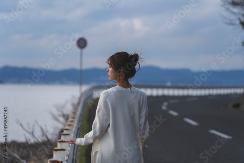 Fototapeta Naklejka Na Ścianę i Meble -  夕暮れの海岸線を歩く女性