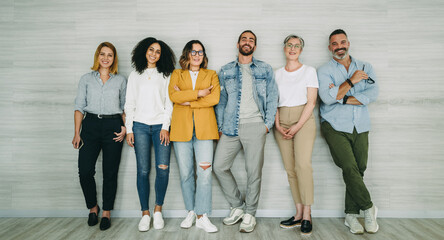Diverse businesspeople standing together against a wall
