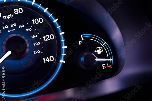 A car interior, the dashboard,instrument panel,and fuel gauge. A speedometer. photo