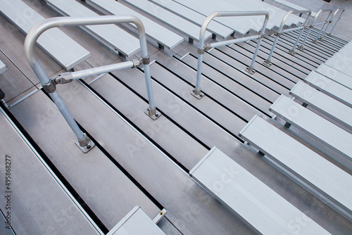 Bleachers, looking down the steep steps and raked seating of a stadium.