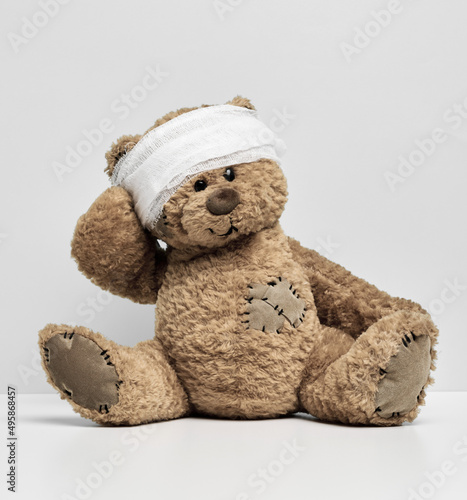 Принти на полотні Children's toy teddy bear sits with a bandaged head