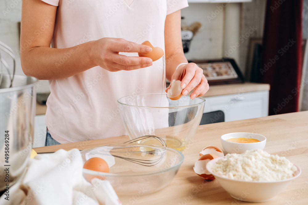 Young woman cooks eggs for breakfast. the process of making omelets, pancakes or meringue Young woman cooks eggs for breakfast. the process of making omelets, pancakes or meringue