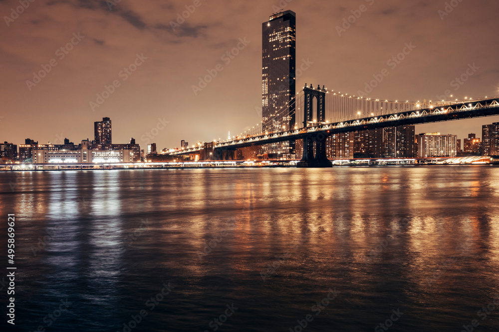 Fototapeta premium manhattan bridge and new york city skyline at night by the bay