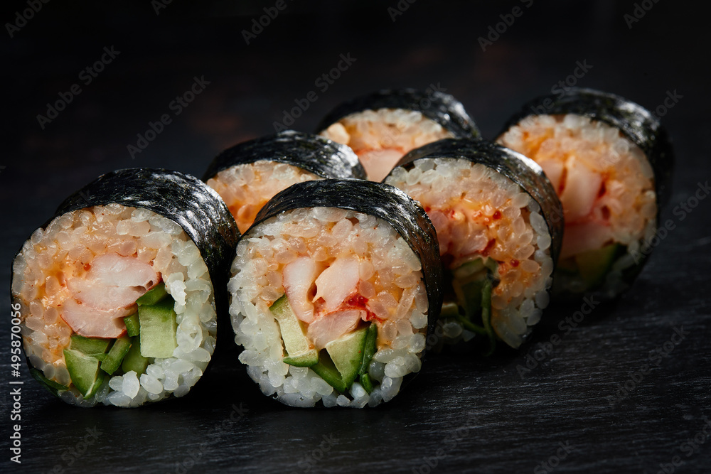 Traditional japanese sushi roll with sea eel, close up isolated on a black background Traditional japanese sushi roll with sea eel, close up isolated on a black background