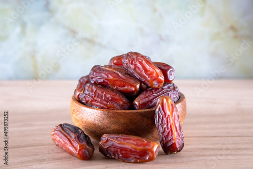 Bowl of dates fruit on wooden background	
