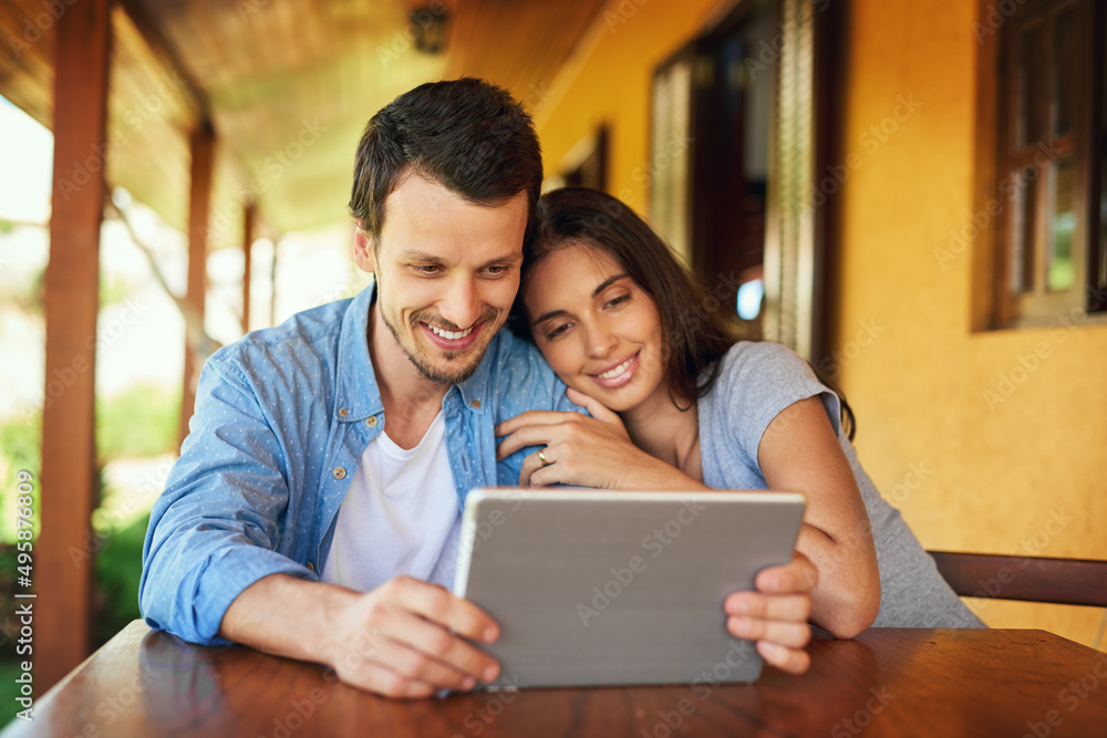 Browsing time is bonding time. Shot of a young couple using a digital tablet together outdoors. Browsing time is bonding time. Shot of a young couple using a digital tablet together outdoors.