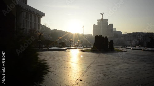 Sunrise over the Maidan in Kyiv. Dawn over the Monument to the Archangel Michael. Flag of Ukraine in the rays of the rising sun photo