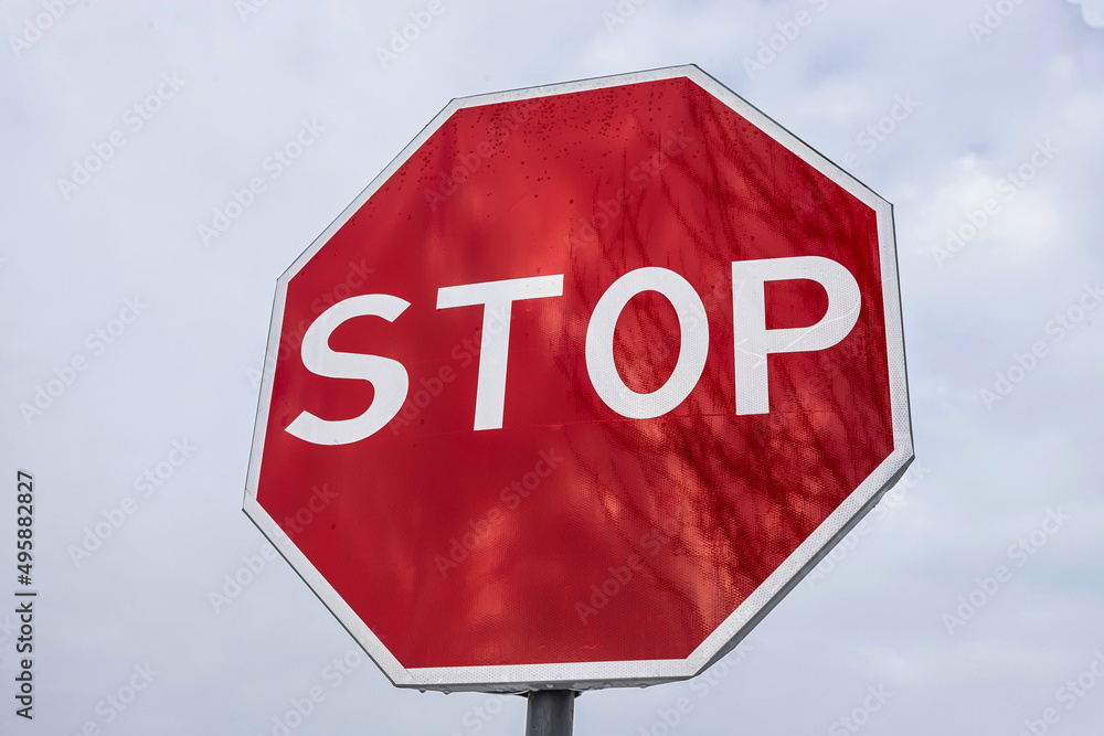 roadside red stop sign on a cloudy background. Sign isolated roadside red stop sign on a cloudy background. Sign isolated