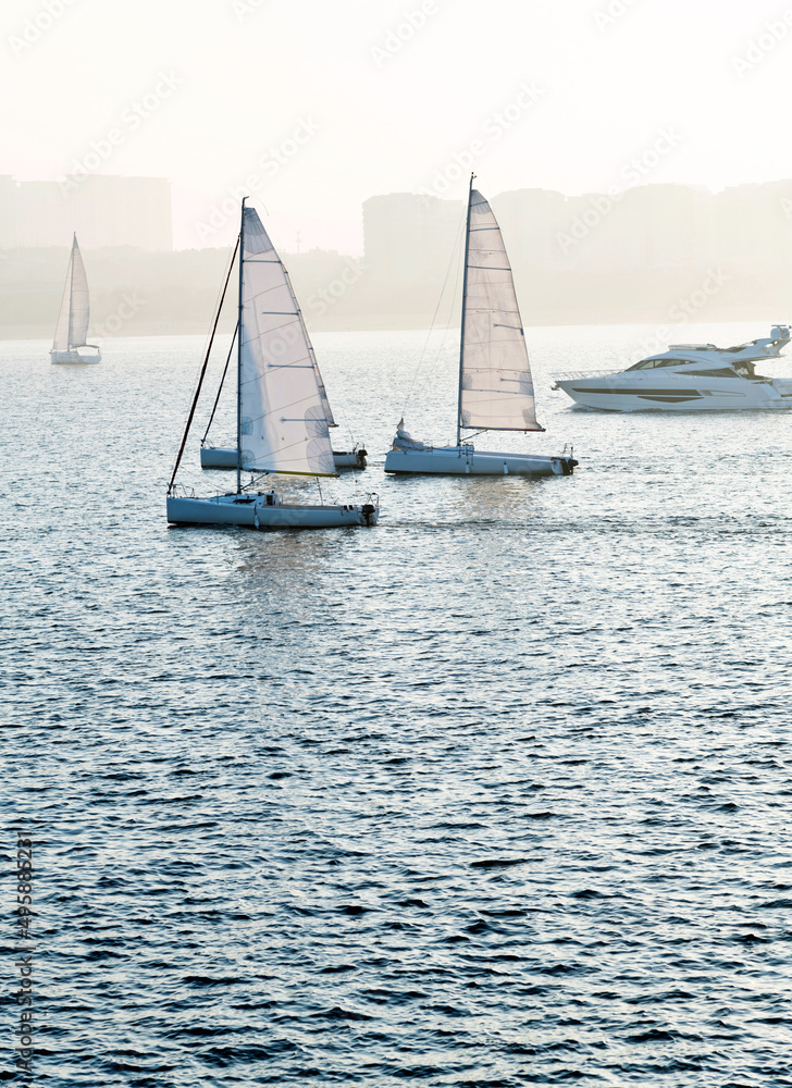 Obraz premium Sailboats in the sea at sunset
