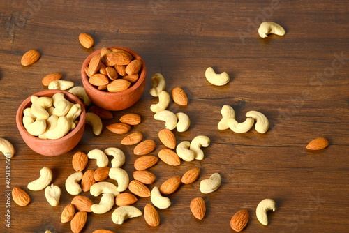 Fresh almonds in the wooden bowl, Organic almonds, almonds border white background, Almond nuts on a dark wooden background. Healthy snacks. Top view. Free space for text. photo