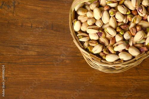 Fresh almonds in the wooden bowl, Organic almonds, almonds border white background, Almond nuts on a dark wooden background. Healthy snacks. Top view. Free space for text. photo