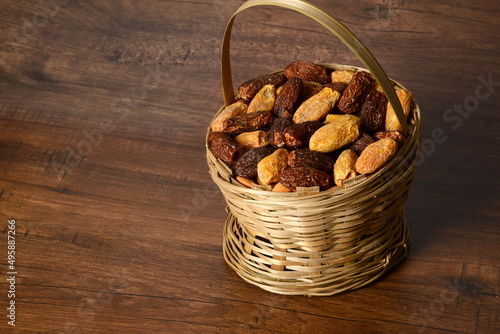 Fresh almonds in the wooden bowl, Organic almonds, almonds border white background, Almond nuts on a dark wooden background. Healthy snacks. Top view. Free space for text. photo