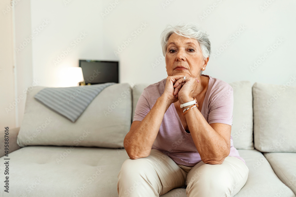Cropped shot of a senior woman looking worried with her hands clasped together at home. Shot of a melancholy senior woman sitting alone in her room at home. Cropped shot of a senior woman looking worried with her hands clasped together at home. Shot of a melancholy senior woman sitting alone in her room at home.